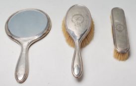 A silver hallmarked 1920's silver dressing table set to include a mirror, hair brush and clothes
