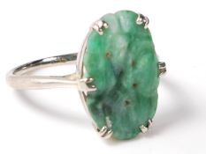 A stamped 9ct white gold ladies ring set with an oval jade panel with carved decoration. Stamped 9ct