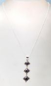A stamped .925 silver pendant necklace having 3 vertical purple stones cased in silver with a silver
