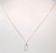 An 18ct rose gold necklace having a oval shaped pendant with a cluster of diamonds set within.