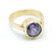A hallmarked 18ct gold ring bezel set with a round cut purple stone. Stone measures approx 8mm