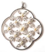An early 20th Century Edwardian Belle Epoch platinum, diamond and pearl pendant of quatrefoil form