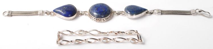 A pair of silver  bracelets, one having 3 lapis lazuli style cabochons and the other having a