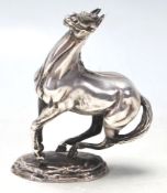 A hallmarked Sterling Silver figurine of a horse rearing set on a naturalistic base. Bearing
