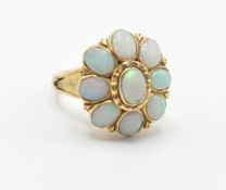 An 18ct gold lady’s dress ring having a flower head set with nine oval opal cabochons with pierced