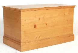 An antique style 20th century country pine blanket box with hinged lid opening to reveal storage