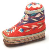 A 20th Century Chinese folk art pin cushion in the form of a shoe having embroidered floral