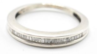 A white gold ladies dress ring with channel set diamonds in a half eternity setting. Size L.