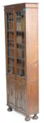 A 1920’s Arts & Crafts oak tall library bookcase cabinet with adjustable shelves, twin leaded and