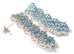 A pair of silver and aquamarine ladies dress earrings set with blue stones within a honeycomb