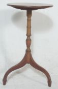 A 19th century George III mahogany tripod wine table being raised on splayed legs with turned