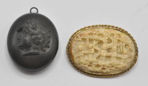 An early 20th Century Chinese carved ivory brooch being intricately carved with elders in a garden