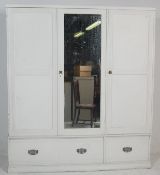 A 19th century Victorian shabby chic painted triple wardrobe being raised on a plinth base with 3