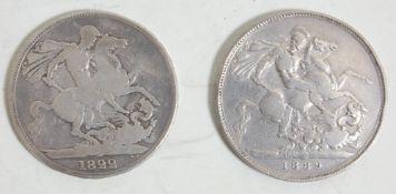 A pair of antique British silver crowns. One coin is dated 1822 with St George killing the dragon to