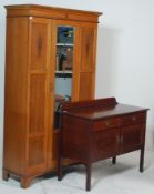 An early 20th century Edwardian oak single wardrobe having a flared pediment top over a mirrored