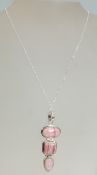 A 925 silver and rose quartz pendant necklace having three geometrical graduated rose stones.