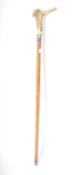 An early 20th walking stick cane having a carved bone handle resembling a pinocchio style