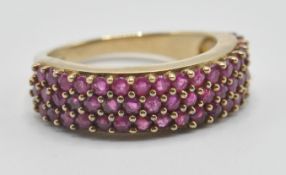 A hallmarked 9ct gold and ruby band ring being set with three rows of pink rubies. Hallmarked