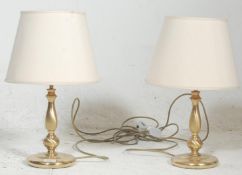 A pair of brass table lamps in the form of candlesticks, circa 20th century having terraced bases