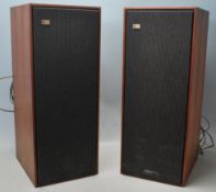 A pair of vintage Bang & Olufsen Beovox 1200 speakers with teak wood case and fabric front cover.
