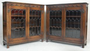 A pair of mid century Jacobean revival sold oak leaded glass bookcase cabinets in the manner of