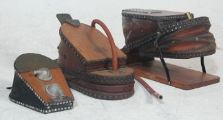 A collection of three 20th century antique foot action black smith belows / foot pumps having wooden