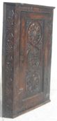 An 18th century George III carved oak corner cabinet having carved central fielded panel door