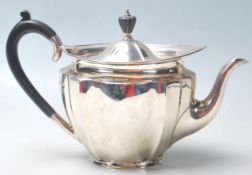A silver hallmarked 1920's John Round & Son teapot having a oval shaped top with carved ebony handle