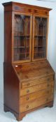 An Edwardian mahogany line inlaid bureau bookcase being raised on bracket feet with a chest of