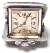 A vintage 1930's folding watch having a brown leatherette case with a square watch face within