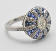 A platinum sapphire and diamond set with a central brilliant cut diamond, the head being set with