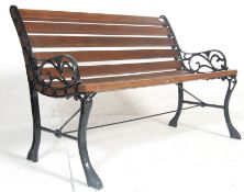 A late 20th Century Victorian style garden bench having wooden slats and shaped foliate bench ends
