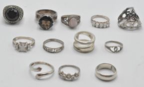 A group of ladies silver ring to include a ring set with  large faceted blue stone, a ring set