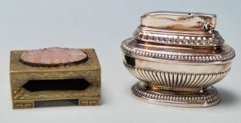 A vintage silver plated Ronson table lighter having a garooned body with beaded borders raised on