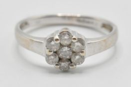 A vintage 20th Century white gold and diamond cluster ring having a flower head set with seven round