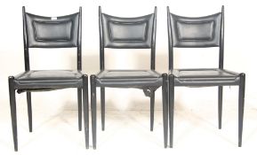 A set of three vintage retro 20th century G plan chairs having black faux leather seat and backrest,