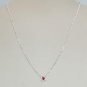 An 18ct white gold necklace pendant set with a a central ruby in a square halo set with diamond