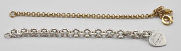 A sterling silver charm bracelet with adorned lobster clasp. The heart shaped pendant marked Tiffany