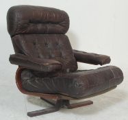 A mid century retro Danish inspired leather patchwork swivel chair - easy armchair. Raised on 4