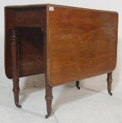 A 19th century George III mahogany drop leaf dining table. Raised on turned legs with castors having