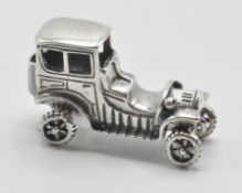 A silver 925 figure of a classic car with spinning wheels. Measure 3cm long, weight: 9g. Stamped