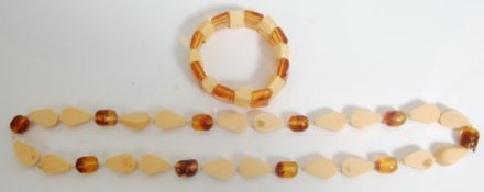 A vintage faux amber necklace and matching bracelet having cream plastic teardrop shaped beads and