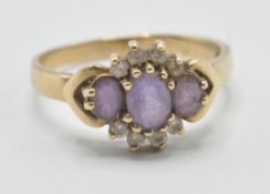 A hallmarked 9ct gold ladies ring being set with three oval cut purple stones with white accent