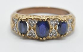 A 9ct gold ladies ring being set with three oval cut blue sapphires with illusion set diamond accent