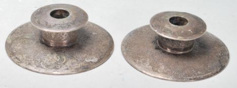A pair of Persian Islamic silver candlestick holders of round form having engraved floral decoration