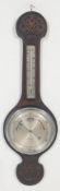 An early 20th century carved oak aneroid wall barometer. The barometer of banjo form having