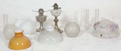 A good collection of 20th century antique oil lamp parts to include milk glass spherical shades, oil