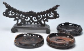 A group of four 20th Century carved Chinese hardwood stands to include a large plate holder with