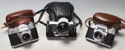A group of three vintage 20th century 35mm photograph cameras to include a Nikkormat 35mm camera