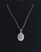 An 18ct white gold, aquamarine and diamond set necklace pendant set to a gold back chai. Stamped 750